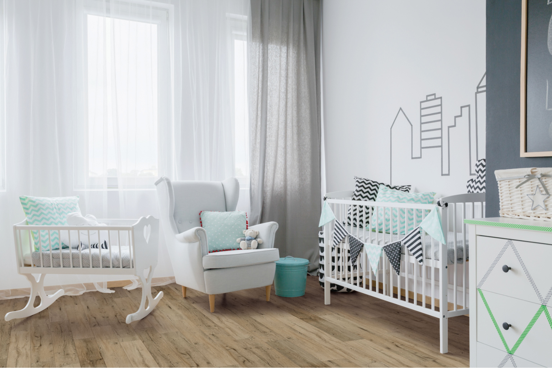 Nursery with wide plank timber flooring, white furniture and light cyan accents