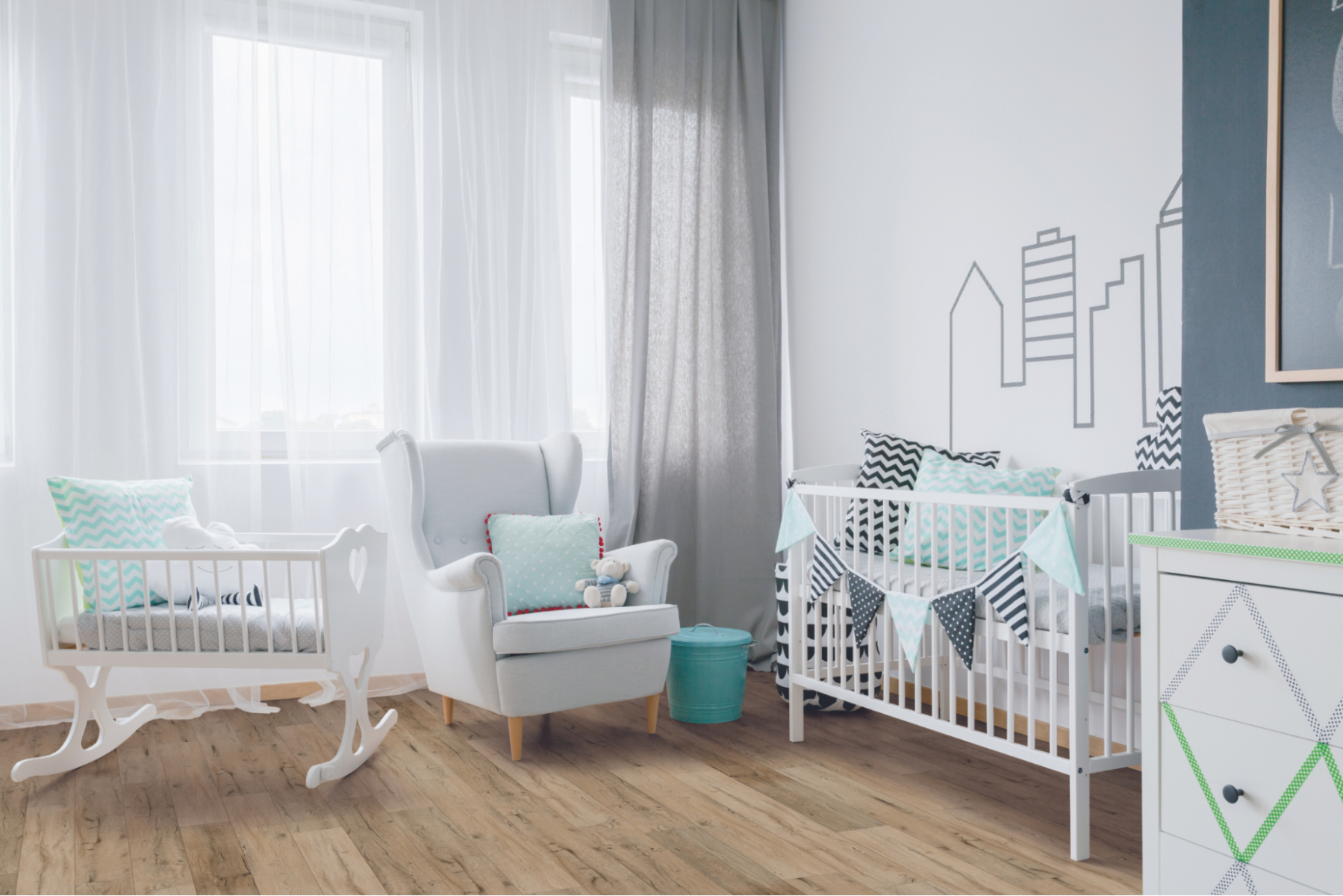 Modern bedroom for a baby featuring white furniture, including two cribs